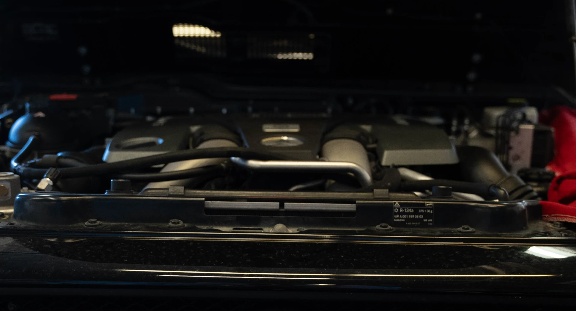 Engine bay of a European car under workshop lights